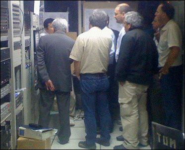 The racks for the Digital Terrestrial Television in the Technical Operations Master room. Some engineers listening to the details of the operation.